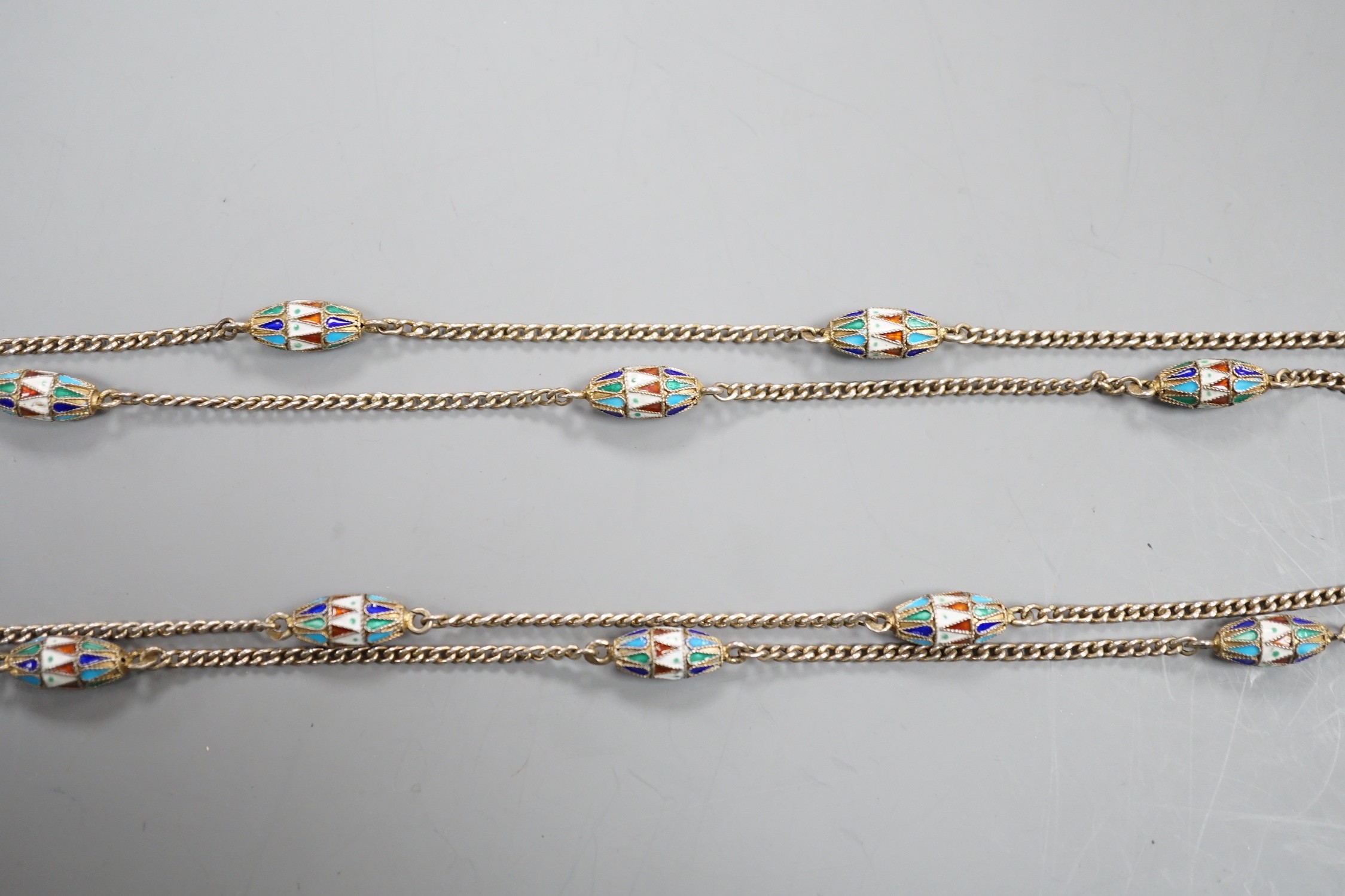 An early 20th century Russian 84 zolotnik and polychrome cloisonné enamel necklace, set with thirteen torpedo shaped enamelled links, 94cm.